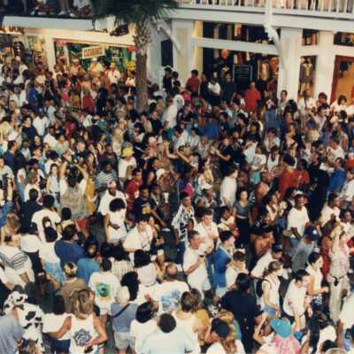 A crowd of unknown people on Duval street near La Conch and the Express store.