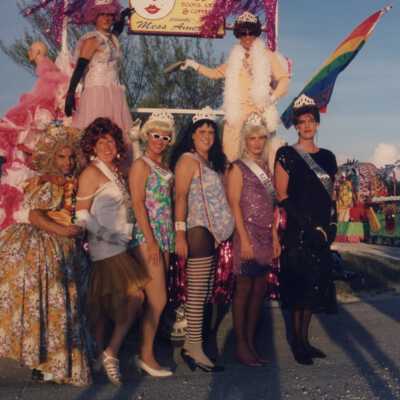 Unknown people dressed up standing next to a float.