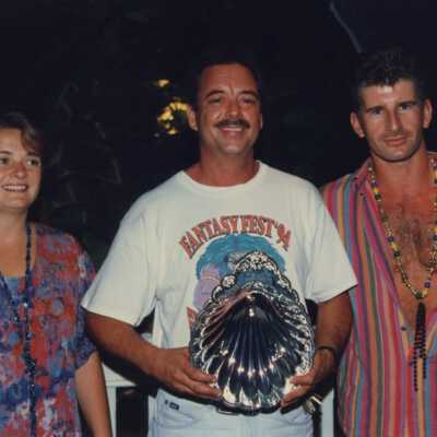 Three unknown people holding an award at the awards ceremony.