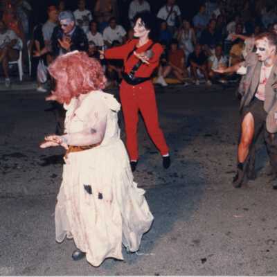 Unknown people dressed up walking in the street for the parade.