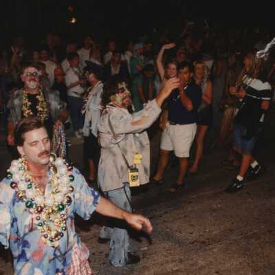 Unknown people dressed up walking in the street for the parade.