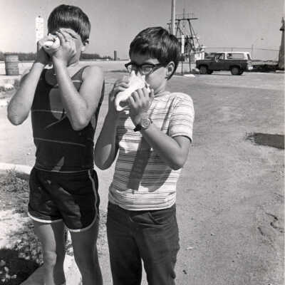Two Boys Blowing Conch Shells