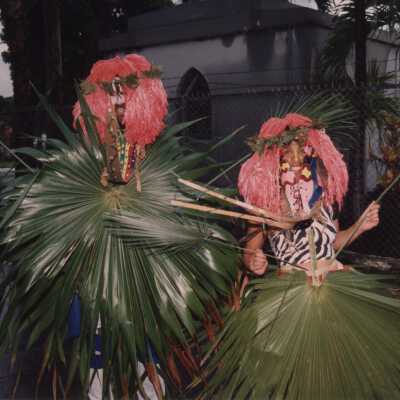 Unknown people dressed up walking by the cemetery.