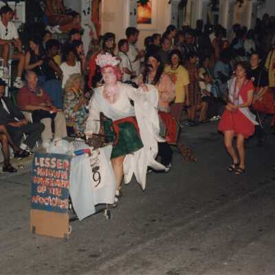 Unknown people dressed up walking in the street for the parade.