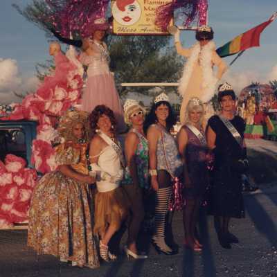 Unknown people dressed up standing in front of a float.