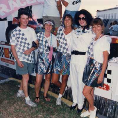 Unknown people dressed up standing in front of a float.