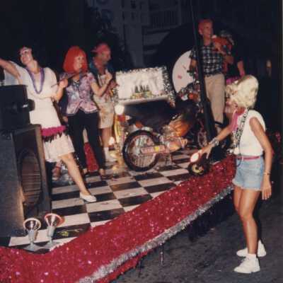 Unknown people dressed up on a float that reads Happy Days.