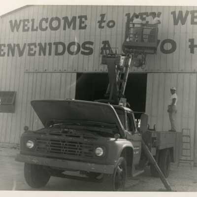 Unknown men on a truck putting up a welcome sign