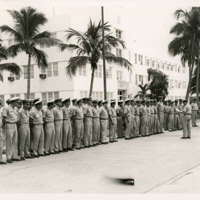 Men in uniform standing while one reads off to them