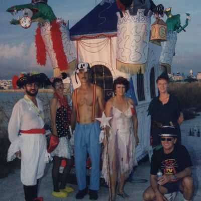 Unknown people dressed up standing in front of a float.