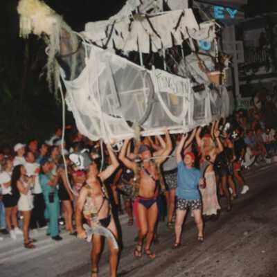 Unknown people in the parade, walking some sort of ship.