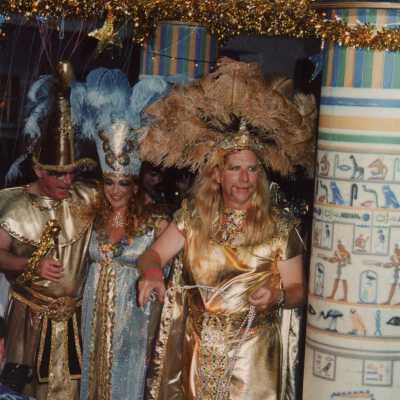 Three unknown people dressed up on a float for the parade.