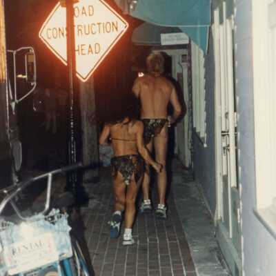 Unknown couple dressed up walking down a street.