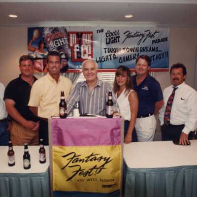 Unknown people standing at the podium at the Fantasy Fest meeting.
