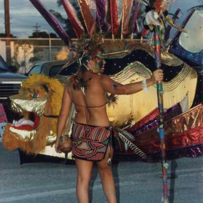 Unknown woman dressed up standing near a float.