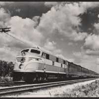          An airplane flying near a Florida East Coast train
   