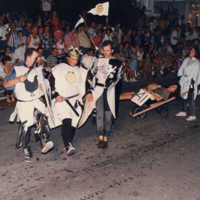 Unknown people dressed up walking in the street for the parade.
