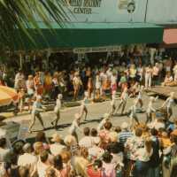 A group of unknown people performing on the street in front of a crowd.