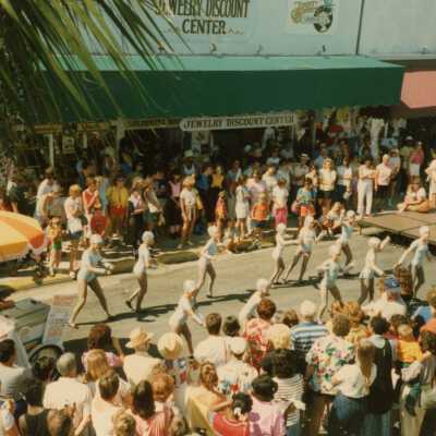 A group of unknown people performing on the street in front of a crowd.