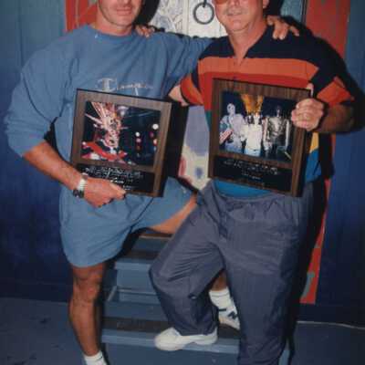 Unknown men each holding a plaque.