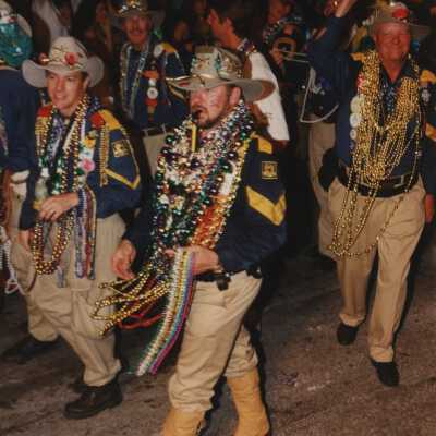 Unknown people dressed up walking in the street for the parade.