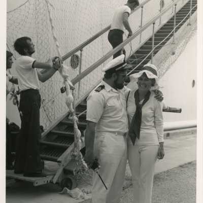 Unknown man in uniform, hugging an unknown woman next to a ship