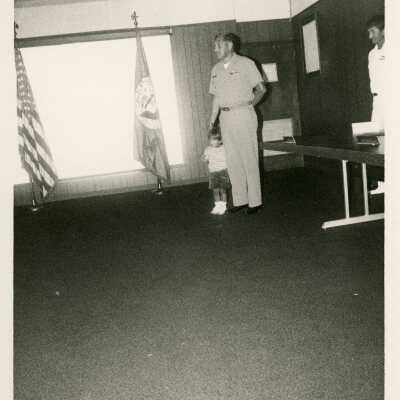 Unknown man in uniform with a child standing next to him