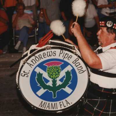 An unknown man in the St. Andrews pipe band from Miami walking in the parade.