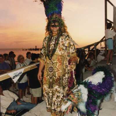 Unknown person dressed up with a dog that is dressed up as well.