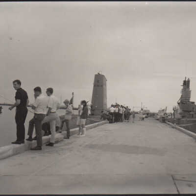People on a pier near submarines