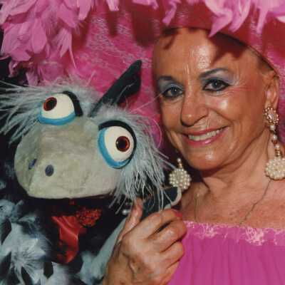 Unknown woman dressed up holding a puppet.