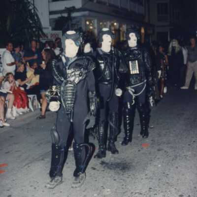 Unknown people dressed up walking in the street for the parade.