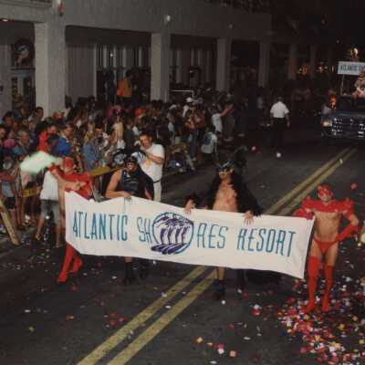 Unknown people walking with the Atlantic Shores Resort banner.