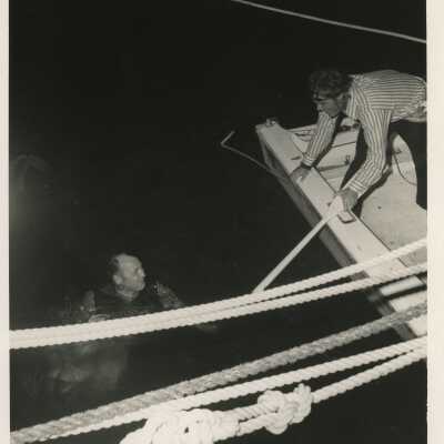 Unknown men one in the ocean and one in a boat