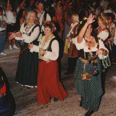 Unknown people dressed up walking in the street for the parade.