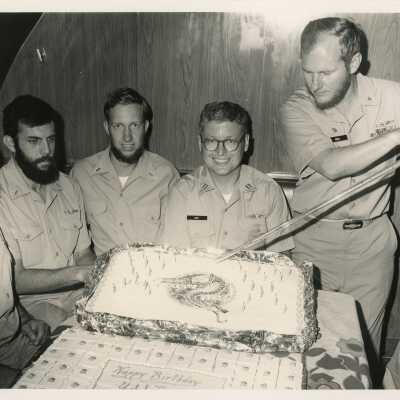 A group of unknown men in uniform with a cake