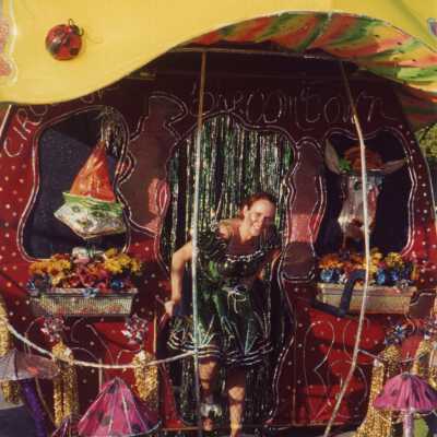 Unknown lady dressed up, standing with a float.