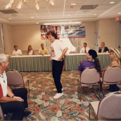 Unknown man showing off a Fantasy Fest t shirt at the meeting.