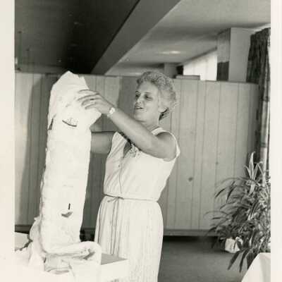Unknown woman holding an unknown object up