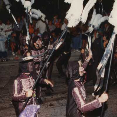 Unknown people dressed up walking in the street for the parade.