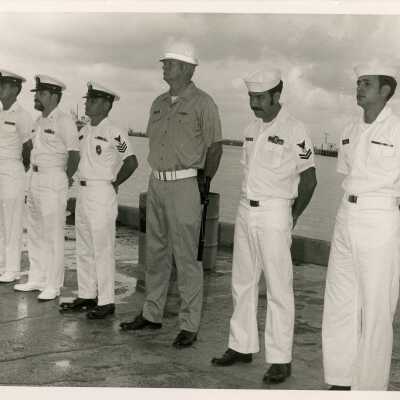 A group of men in uniform standing by the pier