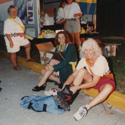 Unknown group of people sitting and standing next to a U-Haul truck.