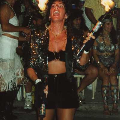 Unknown person dressed up juggling with fire.