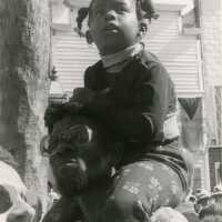 An unknown child sitting on a man