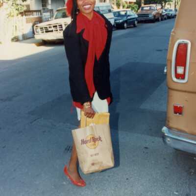 Unknown woman dressed up standing in the street.