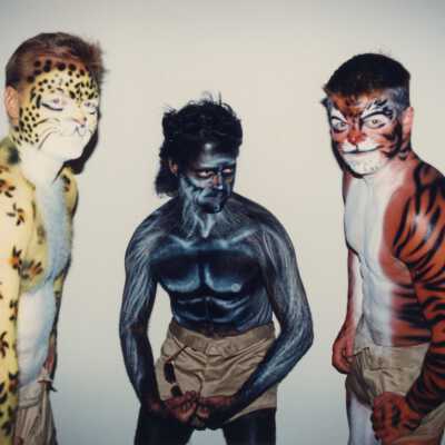 Three unknown men with face and bodies painted.