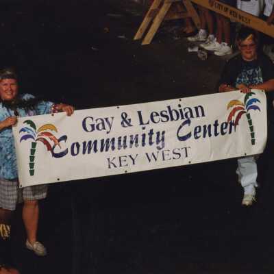 Two unknown woman holding a banner in the parade that reads Gay & Lesbian Community Center.
