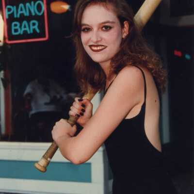 Unknown woman holding a bat.