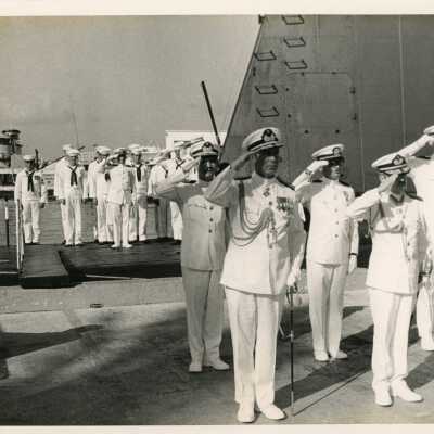 U.S. Navy saluting next to the USS Cubera