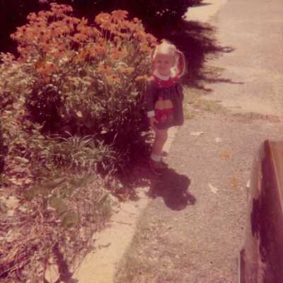 A little girl standing in a yard